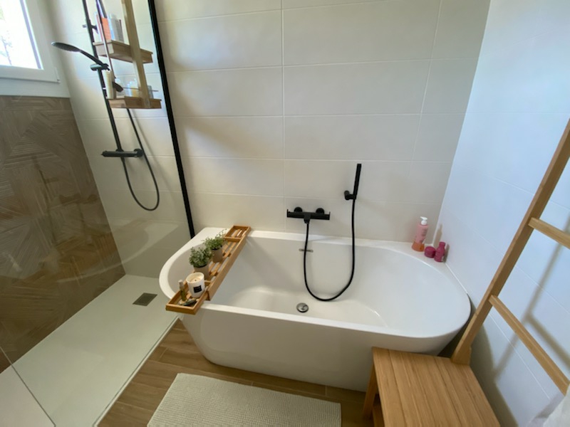 Salle d'eau moderne avec baignoire îlot et touches boisées