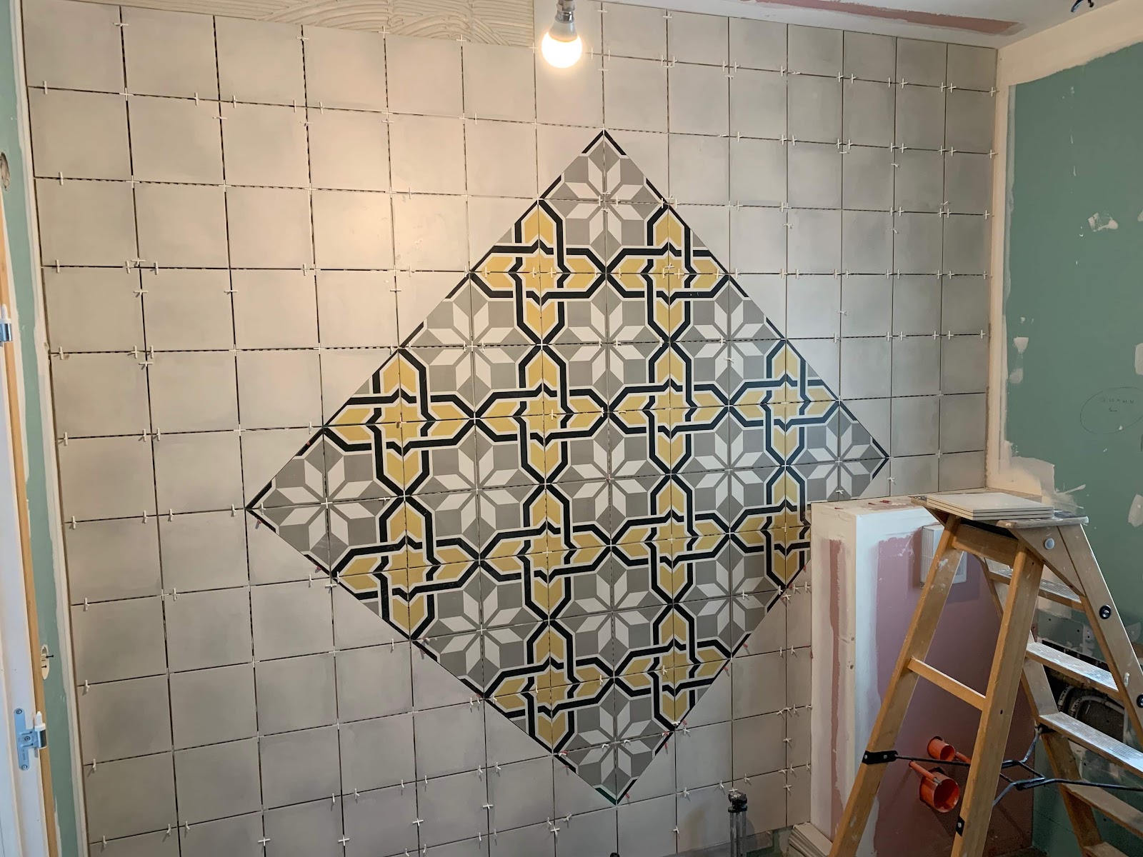 Pose d'un décor mural géométrique en carreaux de ciment